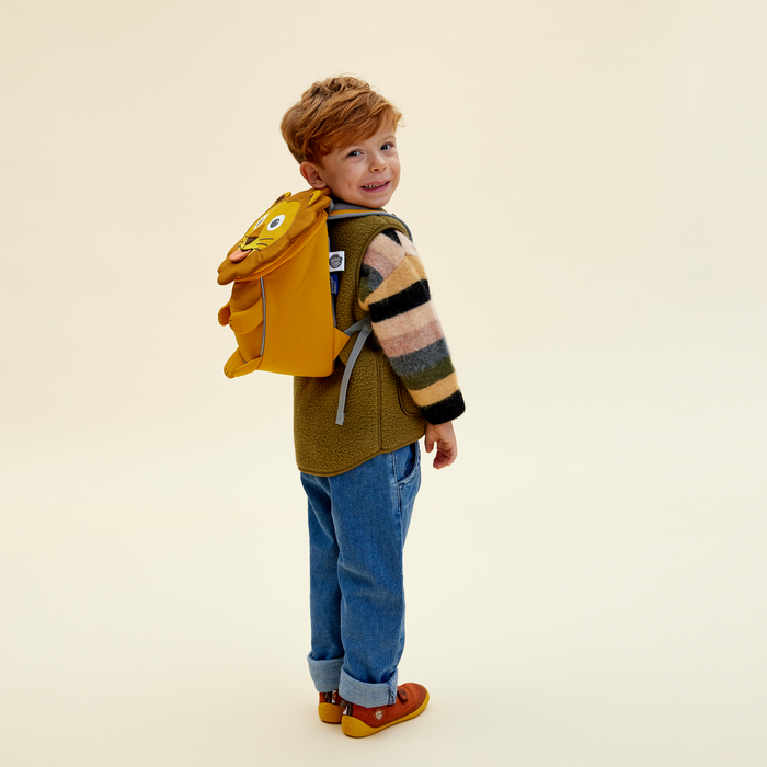 Affenzahn Small Friend Lion backpack worn by a toddler, illustrating its size and fit.