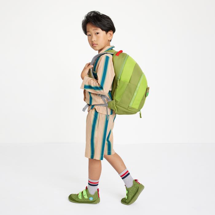 Child wearing the Affenzahn Daydreamer Dinosaur Backpack in green, showing ergonomic straps and spacious design for school or travel.
