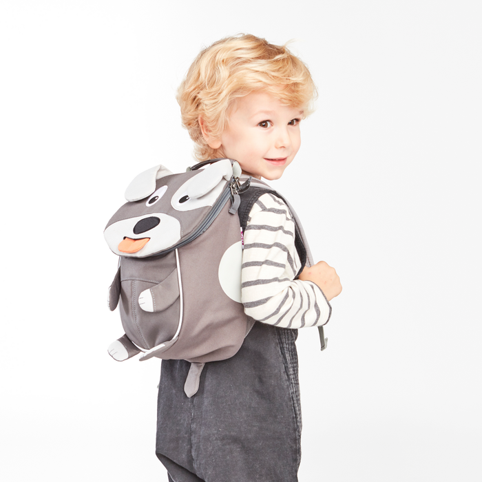 Affenzahn Small Friend Dog backpack worn by a toddler, illustrating its size and fit.