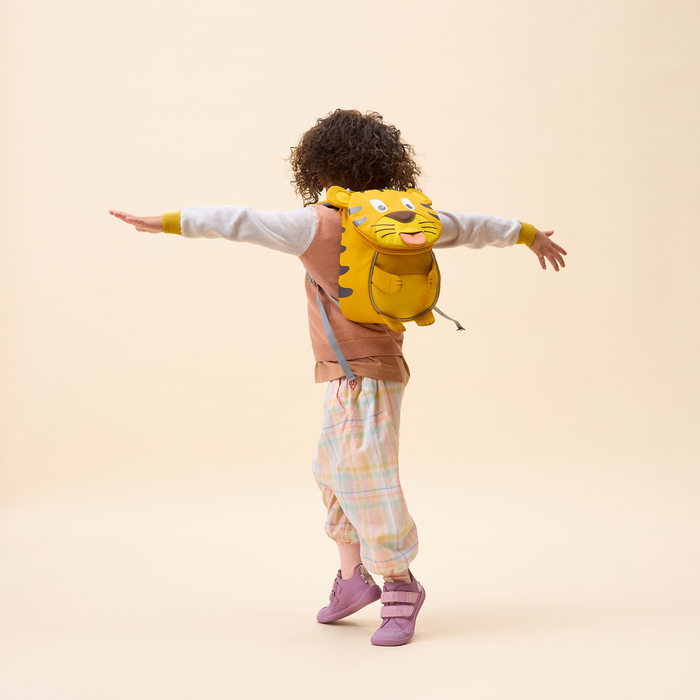 Affenzahn Small Friend Tiger backpack worn by a toddler, illustrating its size and fit.
