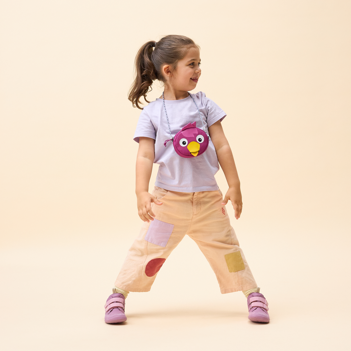 A child wearing the Affenzahn Bird Kids Wallet around the neck, demonstrating the size and the adjustable strap length.