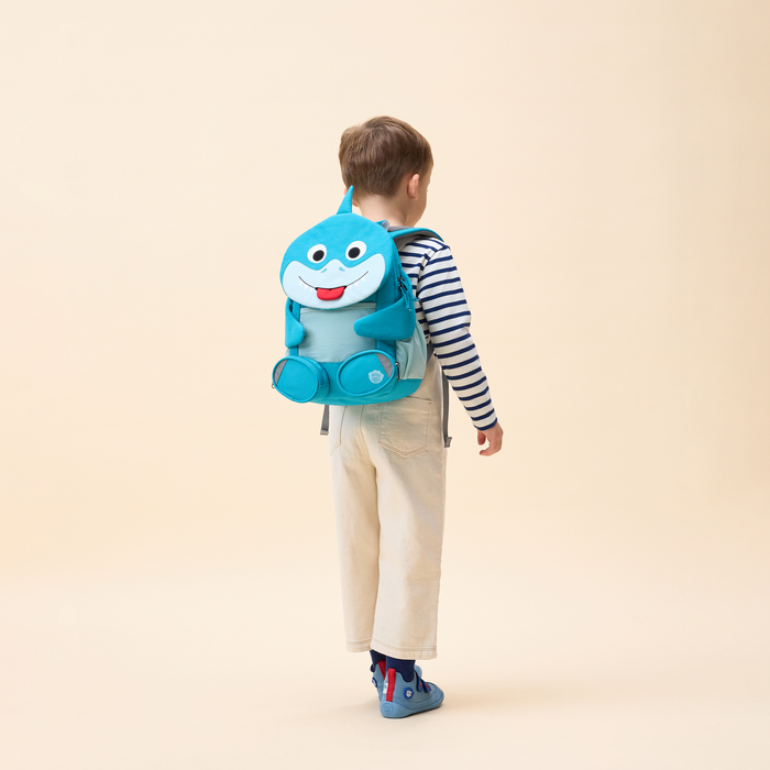 Affenzahn Large Friend Shark backpack worn by a child, illustrating its size and fit.