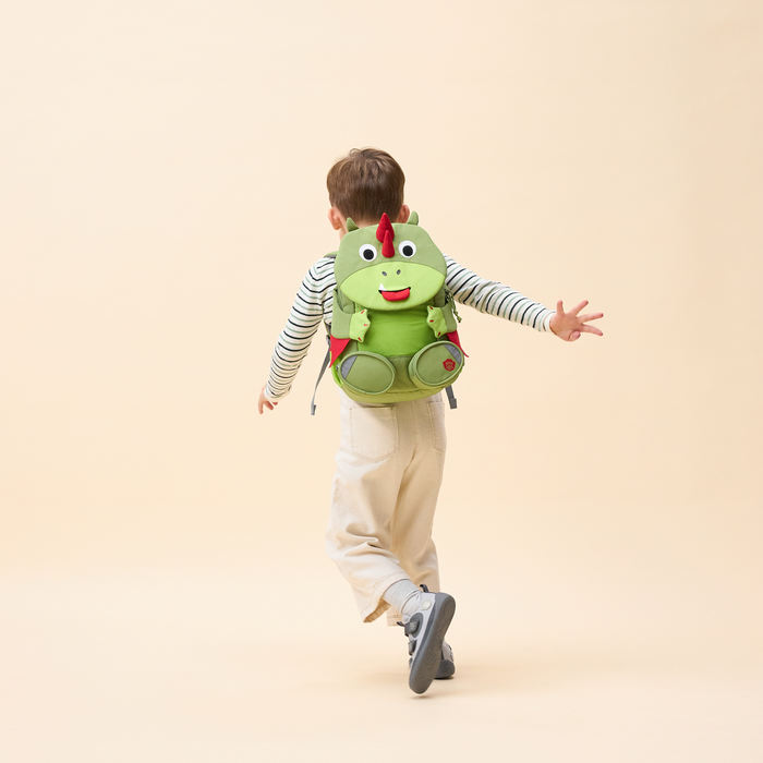 Affenzahn Large Friend Dinosaur backpack worn by a child, illustrating its size and fit.
