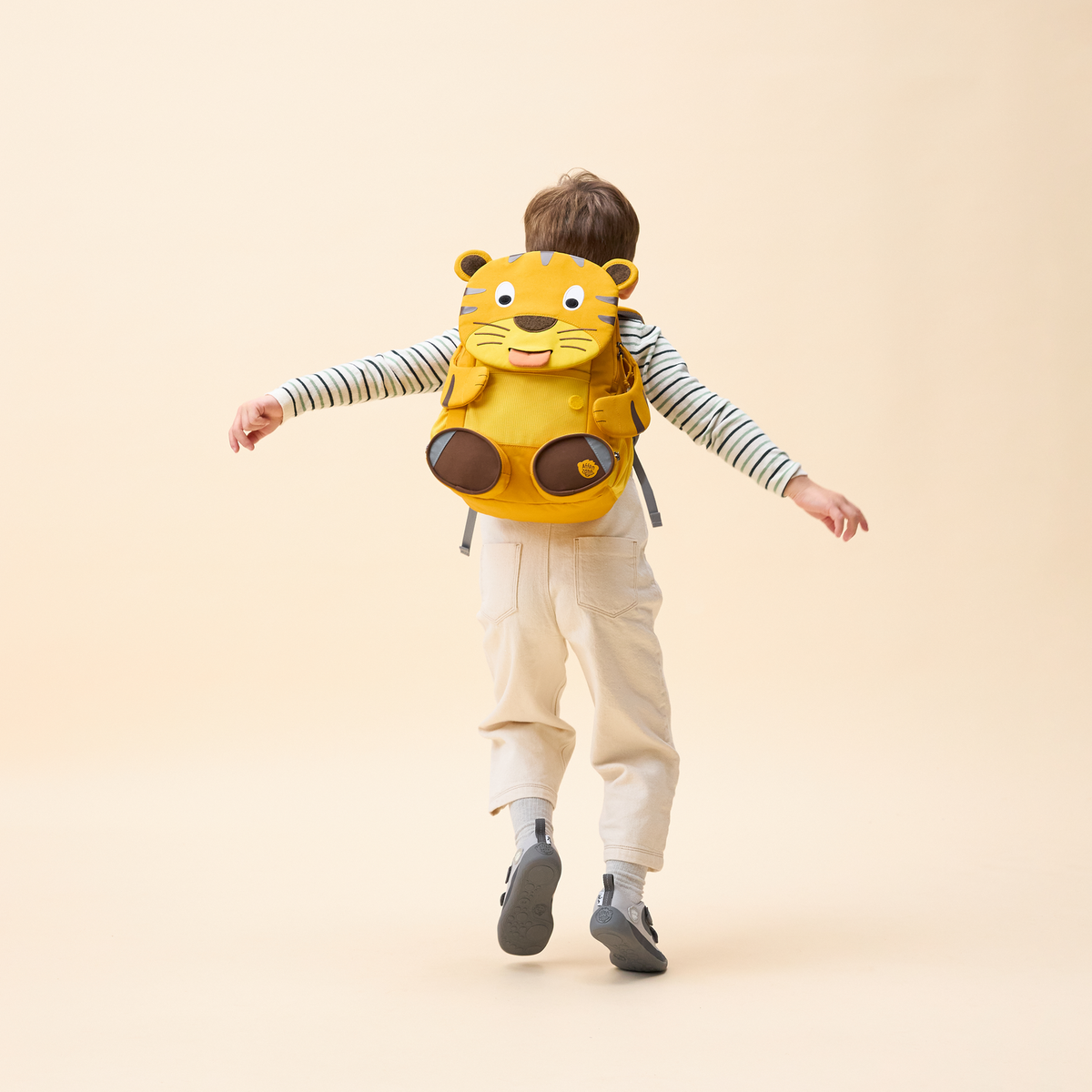 Affenzahn Large Friend Tiger backpack worn by a child, illustrating its size and fit.