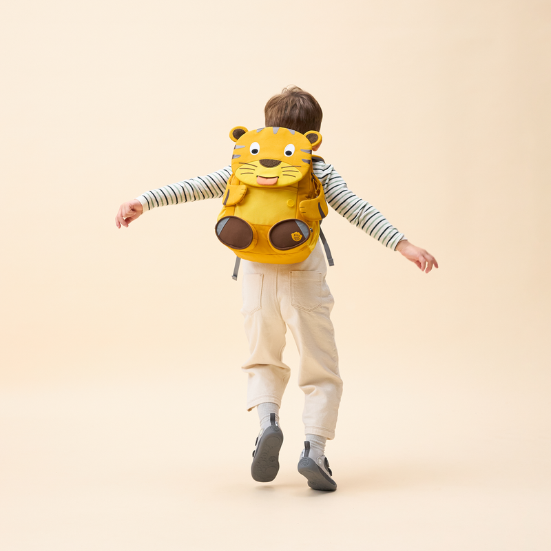 Affenzahn Large Friend Tiger backpack worn by a child, illustrating its size and fit.